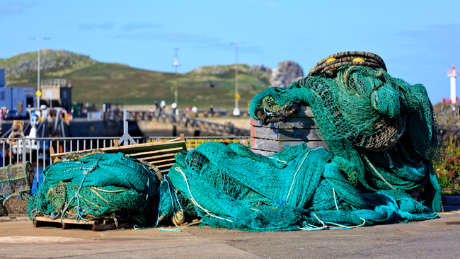 fishing gear and nets in a pile on pier